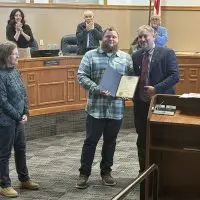Veteran Byron Baird with parents Doug and Nancy Baird receiving proclamation from Mayor Peter Schwartzman in Galesburg
