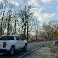 White Chevrolet truck driving on a curved section of South Lake Storey Road in Galesburg^ Illinois^ on February 13^ 2026^ highlighting safety concerns addressed in the February 2026 Traffic Advisory Committee report recommending 25 mph advisory speed limits.