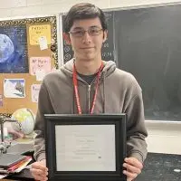 Galesburg High School senior Liam Dilley holds his National Merit Scholarship Certificate of Merit in a classroom at GHS.