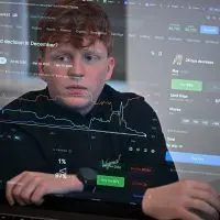 University of Chicago freshman Oliver Wilson analyzes interest rates bets on the Polymarket prediction market platform in his Hyde Park apartment late last year. Polymarket CEO Shayne Coplan has pledged $20^000 to kickstart Wilson’s prediction market club at his university. (Credit: Victor Hilitski/For Illinois Answers Project)