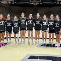 Galesburg girls basketball players posing together on the court during a summer team trip to Purdue