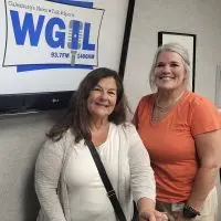 Reina Reyes and Staci Simpson of the Knox Community Health Center standing in front of a WGIL sign