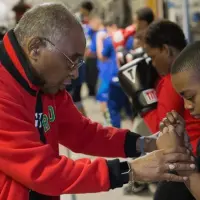 Carlos Duncan wrapping a young boxer's hands at the Galesburg Youth Athletic Club gym