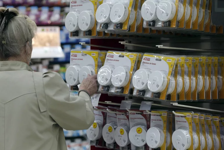 a-shopper-examines-smoke-detectors-which-are-displayed-in-a-supermarket-in-bordeaux