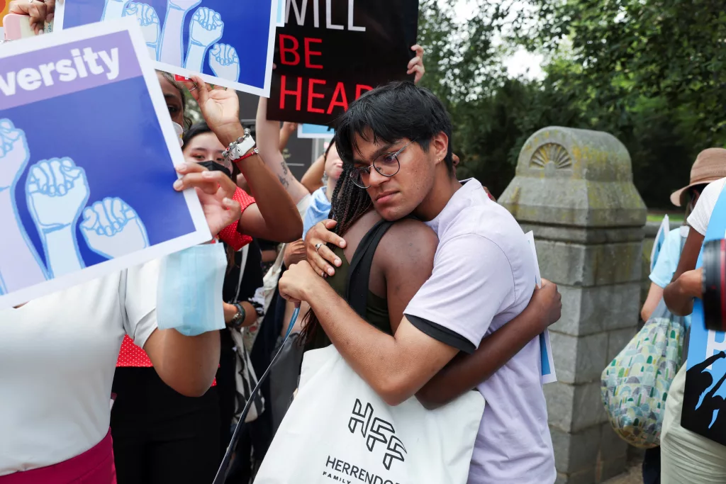People embrace each other as demonstrators for and against the U.S. Supreme Court
