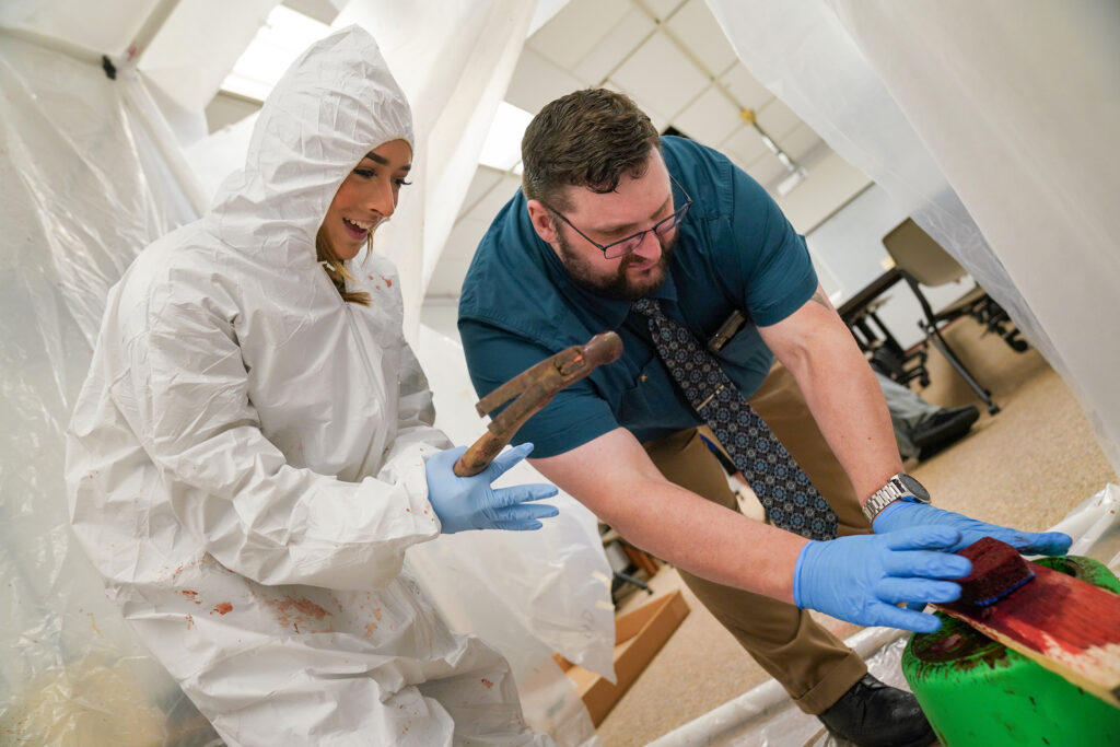 Corissa Wright (left) and Carl Sandburg College criminal justice instructor Dr. Chris Barber conduct a blood spatter experiment in the criminal justice lab on Sandburg's Galesburg campus. 