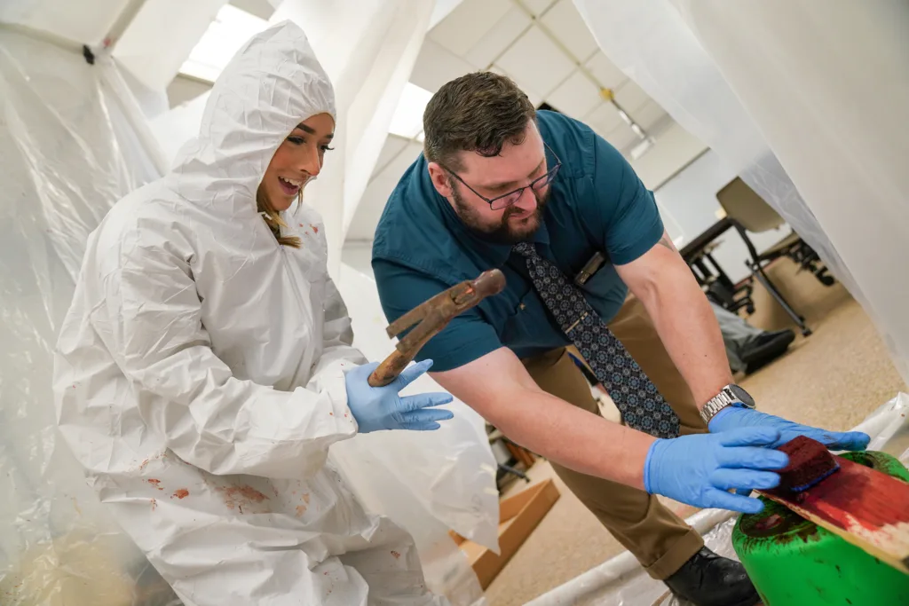 Corissa Wright (left) and Carl Sandburg College criminal justice instructor Dr. Chris Barber conduct a blood spatter experiment in the criminal justice lab on Sandburg's Galesburg campus. 