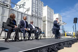 Gov. JB Pritzker speaks at G&W Electric Co. in Bolingbrook to highlight its microgrid, which includes one of the largest batteries in the country. Also pictured (left to right): Bolingbrook Mayor Mary Alexander-Basta, Commonwealth Edison CEO Gil Quiniones, and G&W chair and owner John Mueller. (Capitol News Illinois photo by Andrew Adams)