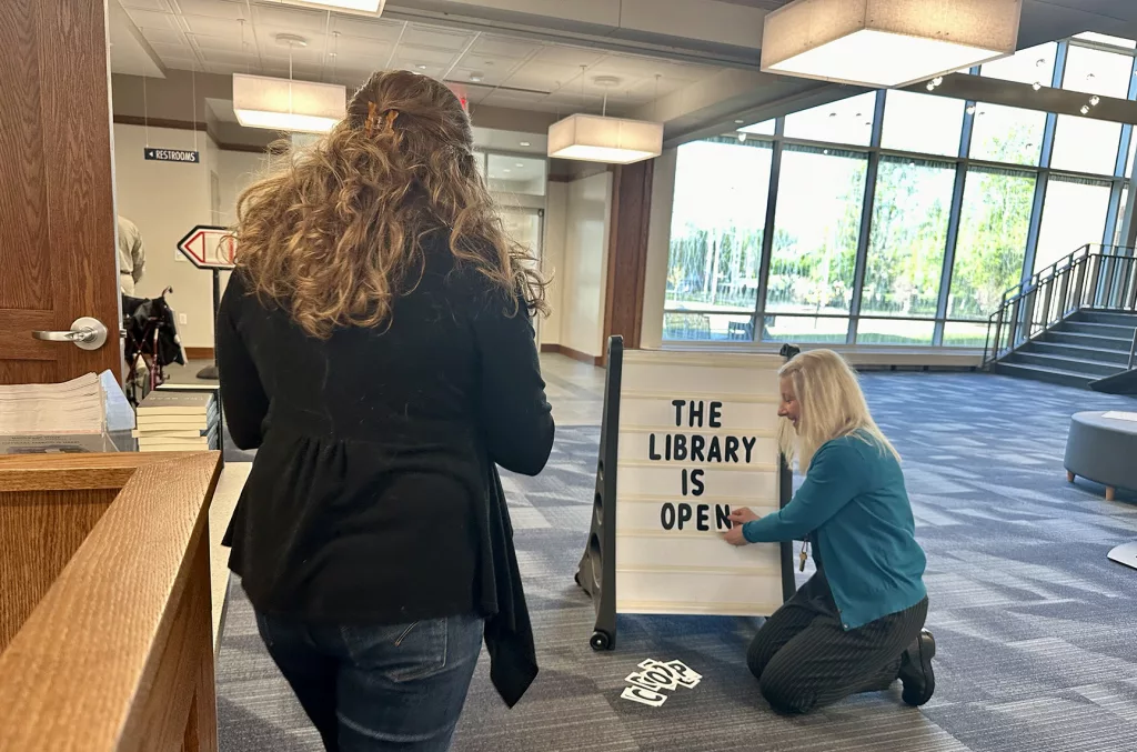 Technical services supervisor Anne Giffey changes the sign from closed to open at the new Galesburg Public Library, 264 W. Main St., on Wednesday, April 24, 2024.