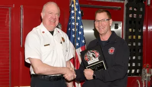 Galesburg Fire Chief presents Captain Matthew Cain with the 2023 Firefighter of the Year award.
