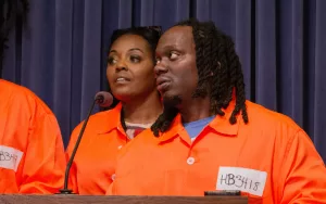 Antonio Lightfoot, deputy director at the nonprofit Workers Center for Racial Justice, speaks at a news conference in the Illinois State Capitol. Advocates wore orange jumpsuits to symbolize the restrictions placed on people who return to society from prison. (Capitol News Illinois photo by Dilpreet Raju)