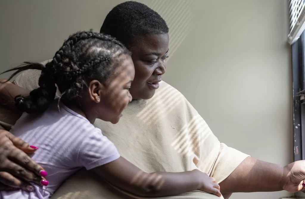 Kaneesha Mallory, 34, looks out the window of her apartment with her 4-year-old daughter Bre’Chelle on April 19, 2024, at the Loarn L. Shuemaker Jr. Building in Cairo. Mallory has lived in Cairo nearly her entire life and returned in 2002 after moving away with her family in 1998. (Photo by Lylee Gibbs, for Capitol News Illinois and the Saluki Local Reporting Lab)