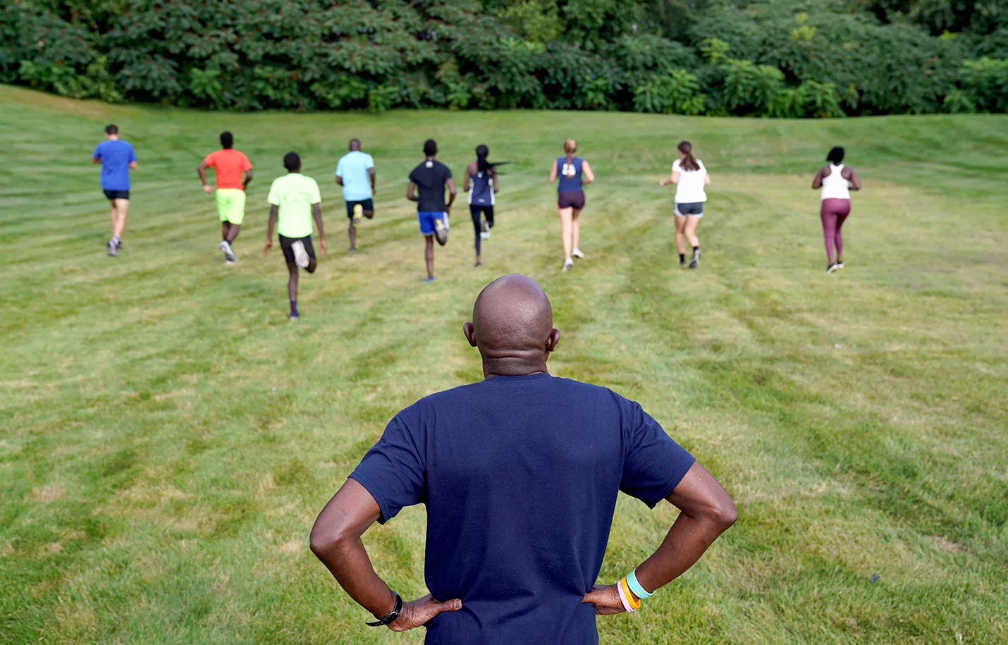 With Coach Rodney Blue looking on, members of the Carl Sandburg College Cross Country men's and women's teams conduct a hill practice behind OSF St. Mary's Medical Center.