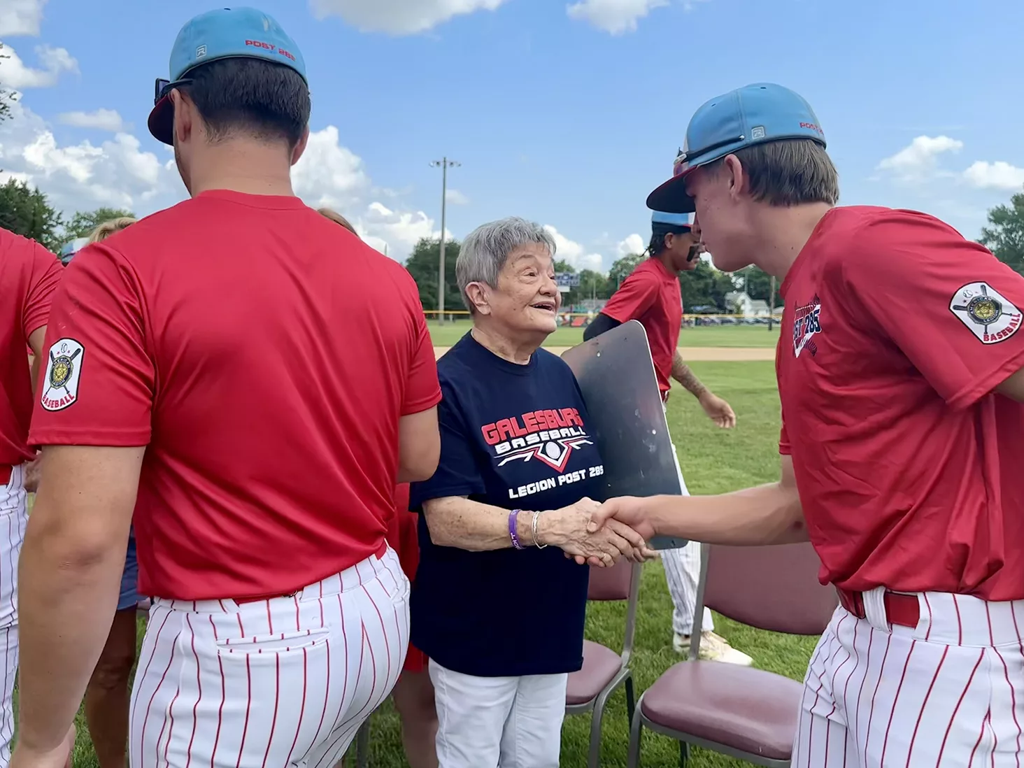 Pat Isaacson greets Galesburg American Legion players following a naming dedication ceremony of Coach Jimmy Isaacson Field on Sunday, July 21, 2024, at H.T. Custer Park.