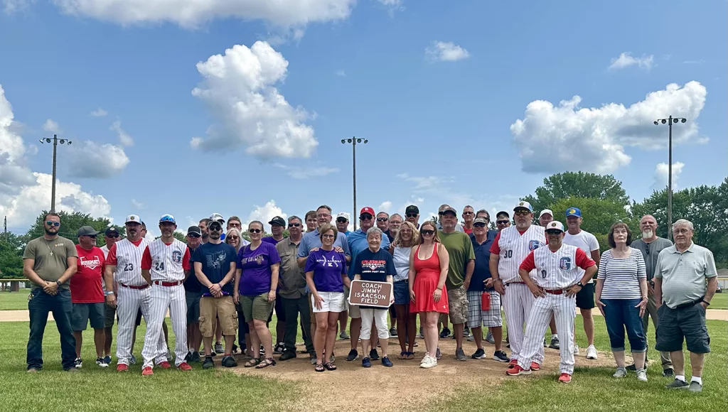 Former players, family and friends pose for a photo following a naming dedication ceremony of Coach Jimmy Isaacson Field on Sunday, July 21, 2024, at H.T. Custer Park.