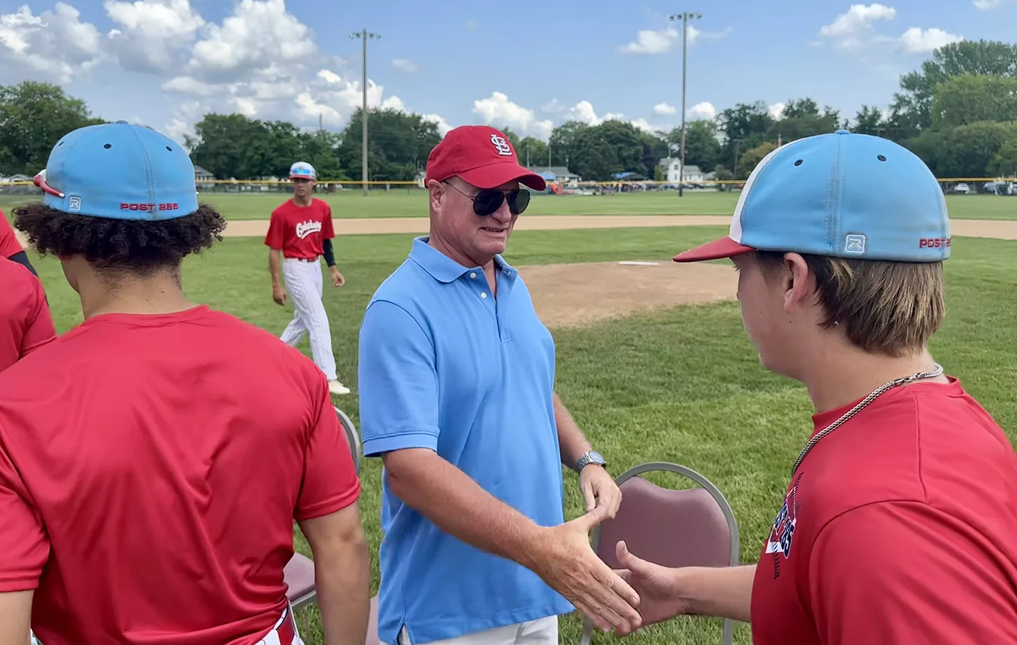Jami Isaacson greets Galesburg American Legion players following a naming dedication ceremony of Coach Jimmy Isaacson Field on Sunday, July 21, 2024, at H.T. Custer Park.