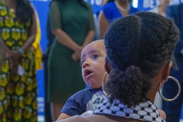 An infant and audience member sit in the crowd of a news conference in Chicago’s Fulton Market District neighborhood. Gov. JB Pritzker signed House Bill 5142 into law, with the hope of lowering infant and maternal mortality rates across the state. (Capitol News Illinois photo by Dilpreet Raju)