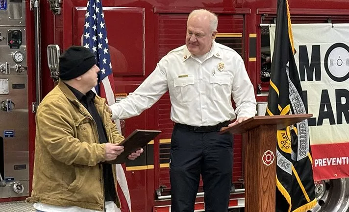 Galesburg resident Joseph Lamnert receives a Civic Excellence Award from Galesburg Fire Chief Randy Hovind during a ceremony Wednesday, Feb. 19, 2025, at Central Fire Station. (JAY REDFERN/WGIL)