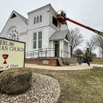 gerlaw-aa: Crews work to secure Gerlaw Christian Church in Warren County on Saturday afternoon. A storm that packed winds between 60 and 80 mph ripped off the steeple of the historic church Friday night. (JAY REDFERN/WGIL)