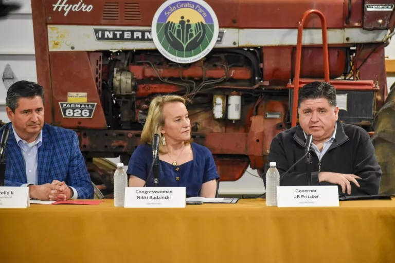 Illinois Gov. JB Pritzker, Congresswoman Nikki Budzinski, and Illinois Department of Agriculture Director Jerry Costello II speak at Sola Gratia Farm in Urbana, Illinois on March 19, 2025. Farmers and environmental leaders were also in attendance to discuss agriculture funding cuts. photo by Jennifer Bamberg, Investigate Midwest