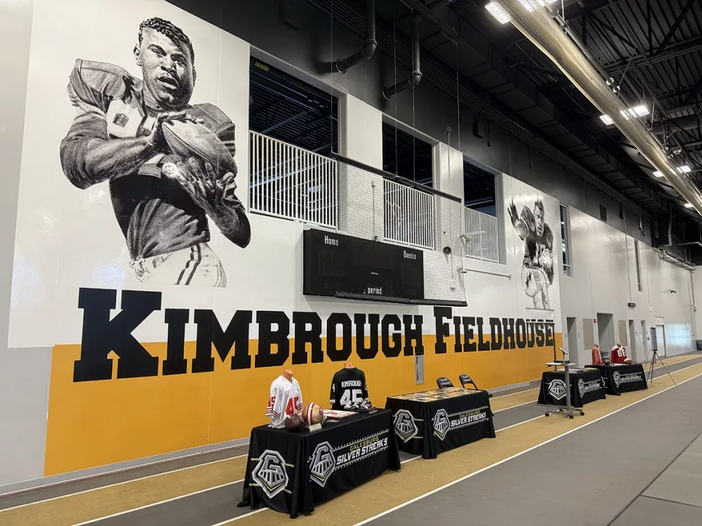A vibrant mural of Albert and Elbert Kimbrough, frozen in their 1950s football glory, now graces the newly christened Kimbrough Fieldhouse at Galesburg Jr./Sr. High School, unveiled during a heartfelt dedication ceremony on Sunday, May 25, 2025.