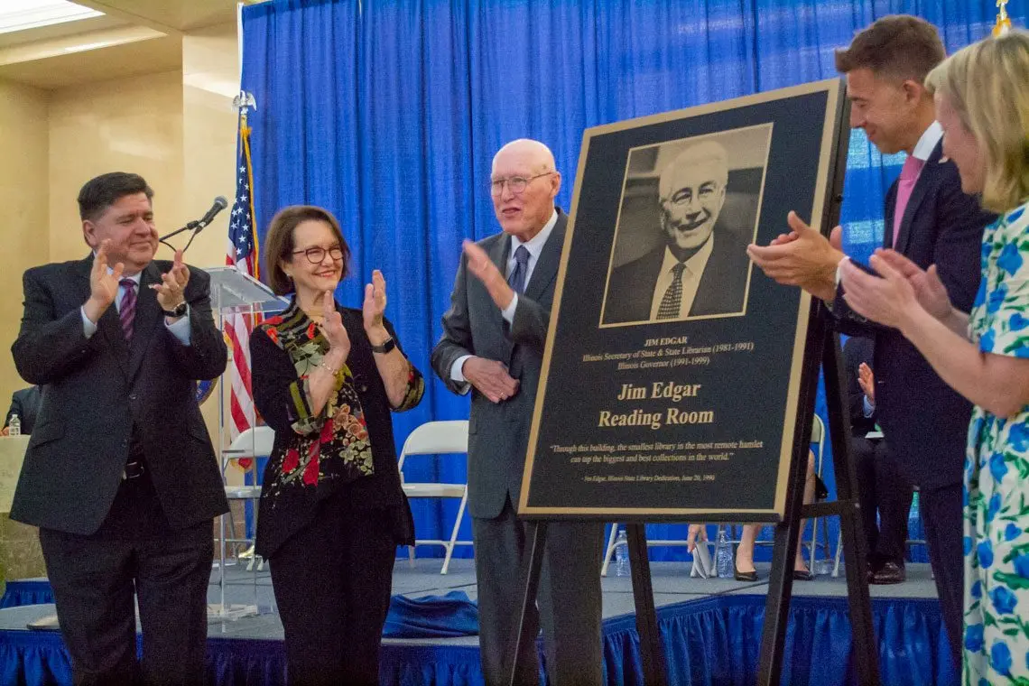 Former Republican Gov. Jim Edgar, center, unveils a plaque honoring his name on the reading room at the Illinois State Library. Also pictured are Gov. JB Pritzker, Edgar’s wife Brenda, Secretary of State Alexi Giannoulias and Congresswoman Nikki Budzinski. (Capitol News Illinois photo by Jerry Nowicki)