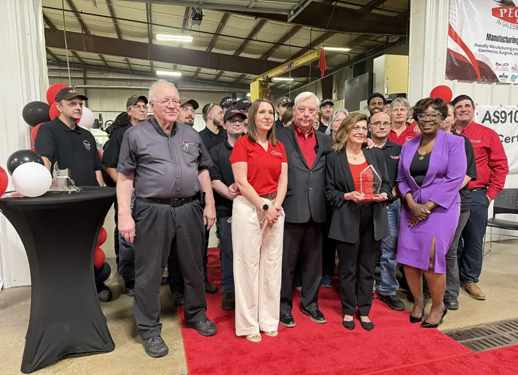 Ruth Whitehead (center), CEO of Pegasus Manufacturing, Inc., holds her award for the 2025 SBA Illinois Manufacturer of the Year with employees during an awards ceremony at Pegasus on June 5,2025. Her husband and co-owner Ray Whitehead (left of Ruth) and SBA Illinois District Director Willette LeGrant (right of Ruth). (JAY REDFERN/WGIL)