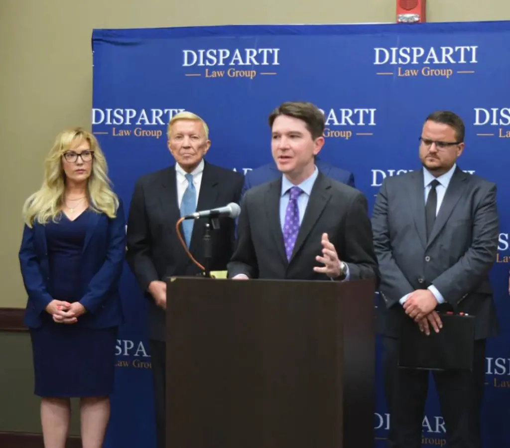 Sen. Steve McClure (podium), R-Springfield, speaks about the lawsuit next to Cass Casper, the lead attorney on the case (middle), and the victim’s parents (right), at a news conference in Springfield on Tuesday. (Capitol News Illinois photo by Jade Aubrey)