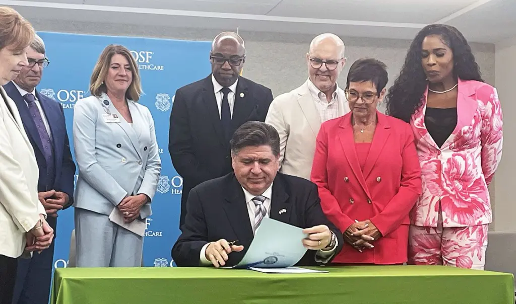 Gov. JB Pritzker signs two bills related to health care costs at a hospital in Peoria, including a bill that puts more controls on pharmacy benefit managers. (Capitol News Illinois photo by Andrew Campbell)
