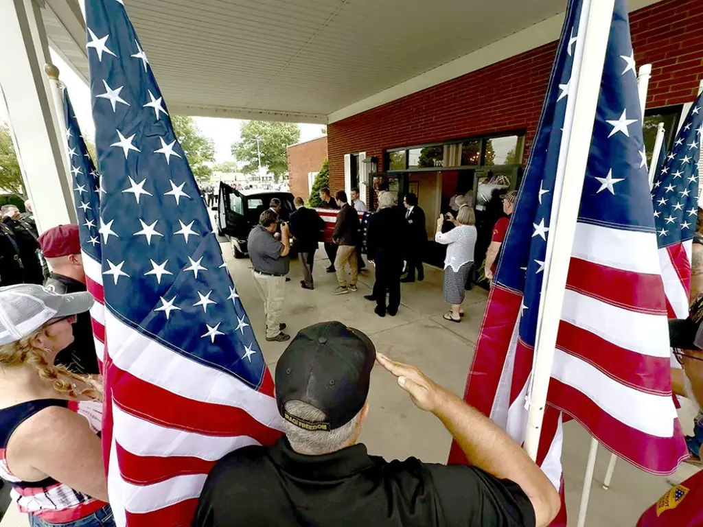 State Rep. Dan Swanson, Woodhull, salutes as the flag-draped casket of Cpl. Paul Hoots is loaded into a hearse Thursday, July 24, 2025, at Hinchliff-Pearson-West Funeral Directors in Galesburg.