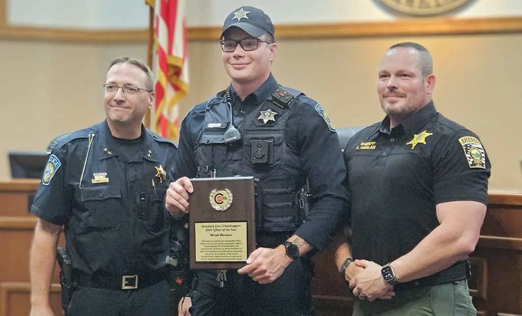 Galesburg Police Officer Noah Harlan, center, is the 2024 Galesburg Area CrimeStoppers Officer of the Year. Also pictured are Galesburg Police Chief Kevin Legate, left, and Knox County Sheriff Jack Harlan. (WGIL)