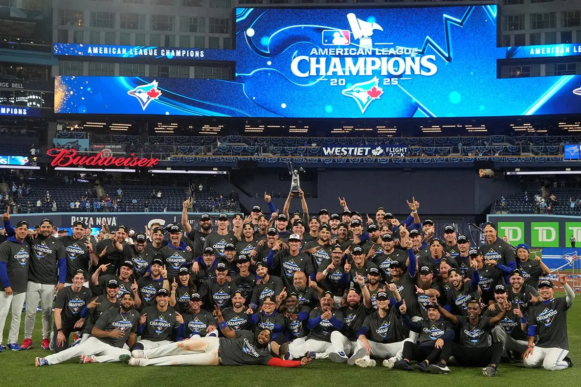 The Toronto Blue Jays celebrate on the field after defeating the Seattle Mariners in game seven of the ALCS round for the 2025 MLB playoffs at Rogers Centre. Alexis native and Blue Jays bullpen coach Graham Johnson is pictured in the front row, third from left. (John E. Sokolowski-Imagn Images/File Photo)