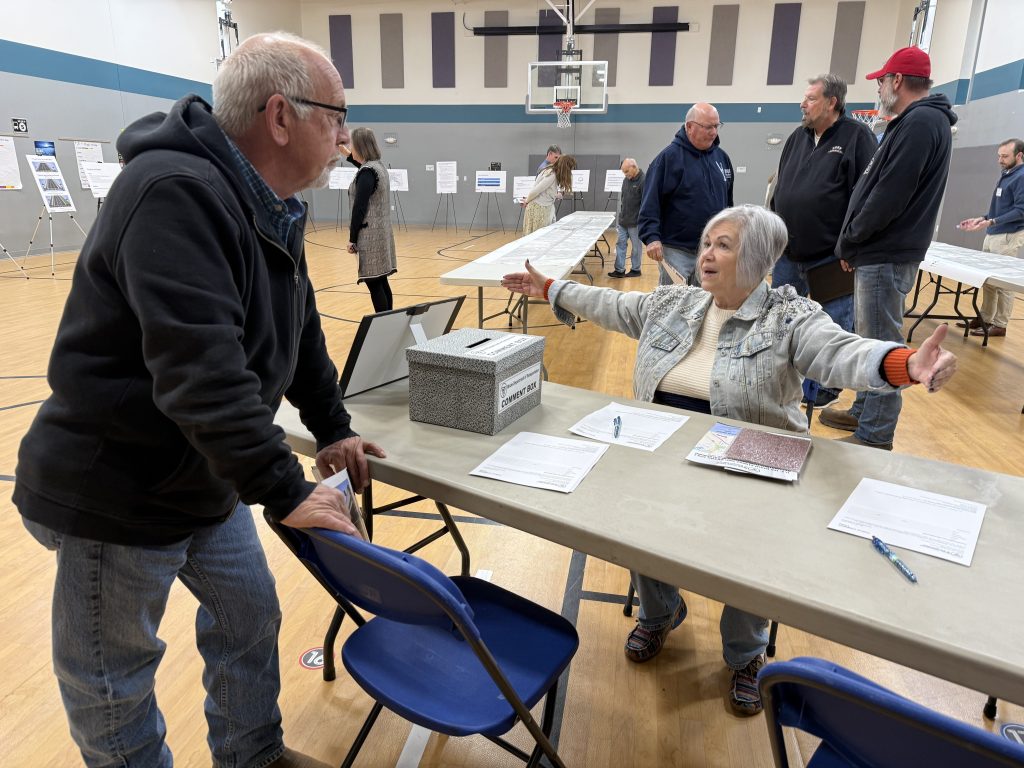 Grand Avenue resident Vicki Mohr (arms outstretched) discusses the long-awaited U.S. 150 reconstruction project with Ward 3 Alderman Evan Miller during Thursday’s IDOT open house at King Elementary School. Mohr told WGIL she’s ‘looking forward to the improvements for sure’ — even though construction can’t start before 2029. (JAY REDFERN/WGIL)