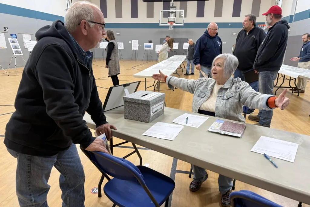 Grand Avenue resident Vicki Mohr (arms outstretched) discusses the long-awaited U.S. 150 reconstruction project with Ward 3 Alderman Evan Miller during Thursday’s IDOT open house at King Elementary School. Mohr told WGIL she’s ‘looking forward to the improvements for sure’ — even though construction can’t start before 2029. (JAY REDFERN/WGIL)
