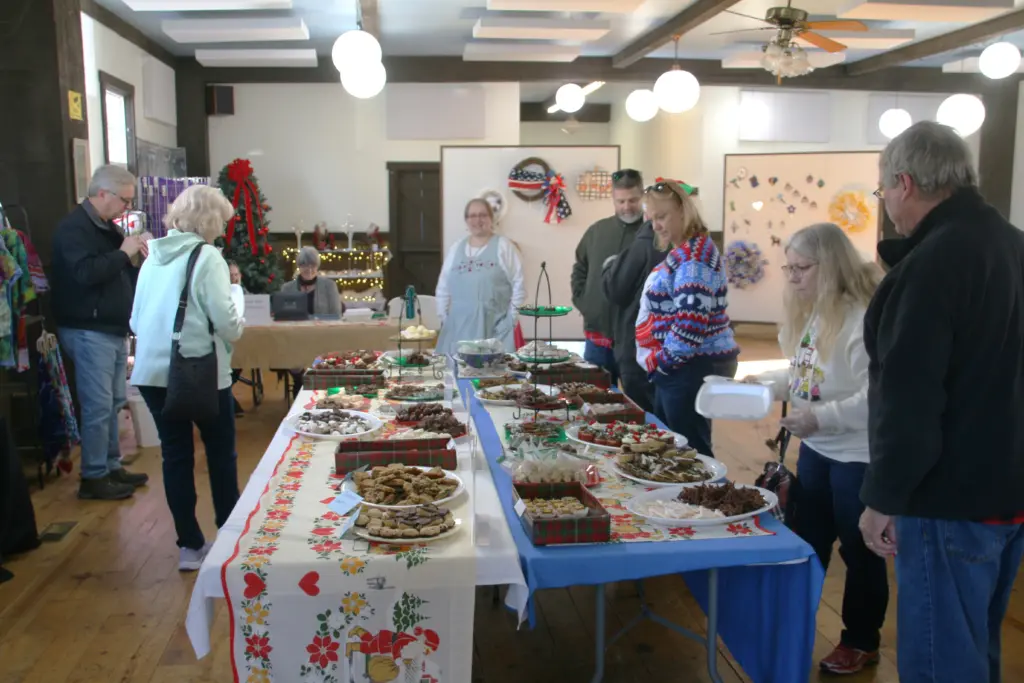 Visitors browse long tables loaded with dozens of varieties of homemade chocolates during the annual Chocolate Walk at Bishop Hill’s Julmarknad Swedish Christmas market.