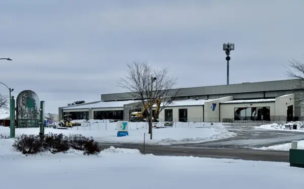 Snow-covered view of the Hollow Tree Apartments sign and the YMCA building along West Carl Sandburg Drive in Galesburg, Illinois, under cloudy skies on Sunday, Nov. 30, 2025.