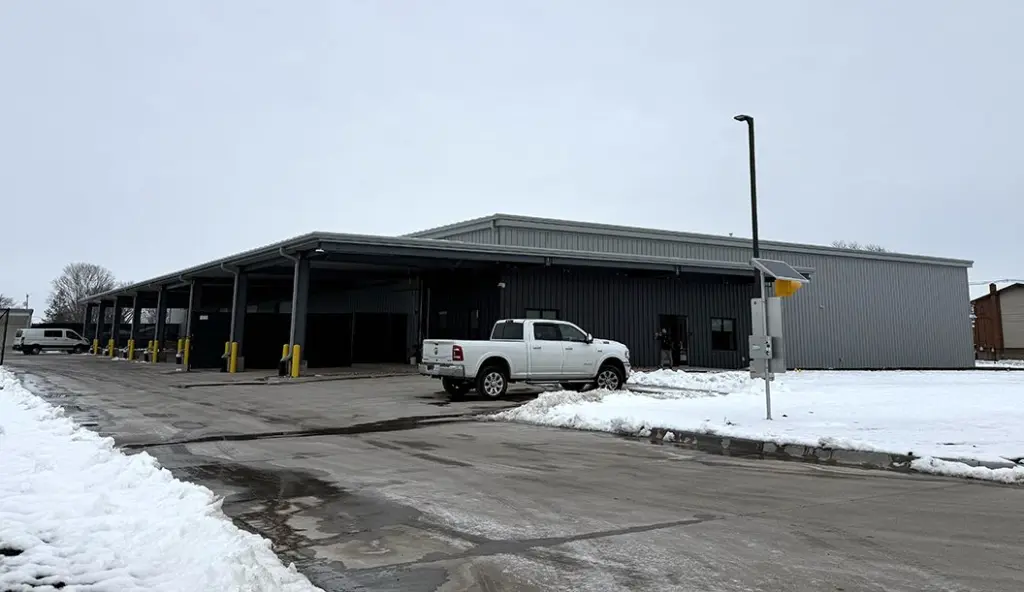 New Galesburg District 205 warehouse on Dayton Street at Galesburg High School campus, gray metal building with covered loading docks and snow on the ground.