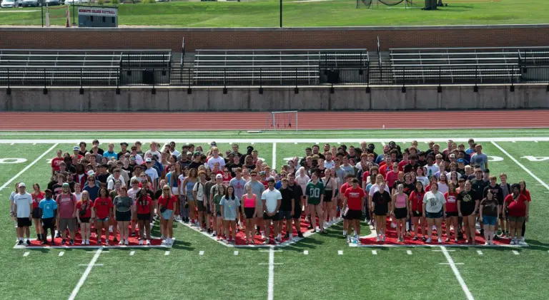 Large group photo of Monmouth College’s fall 2025 incoming class (265 students) on the football field – the college’s biggest freshman/transfer class in ten years.