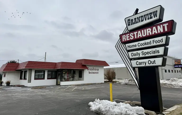 Grandview Restaurant sign and building at 2221 Grand Ave. in Galesburg after announcing permanent closure in December 2025. Snow on the ground, empty parking lot.