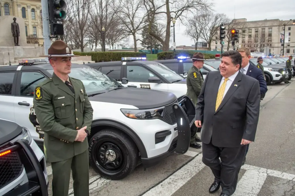 Gov. JB Pritzker passes in front of a row of Illinois State Police vehicles during a ceremony outside the Illinois Capitol in Springfield on March 30, 2022. (Capitol News Illinois photo by Jerry Nowicki)