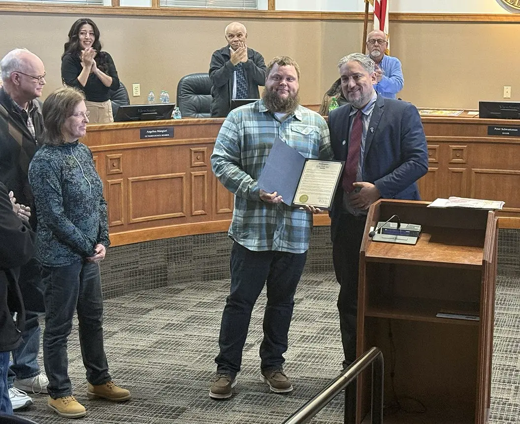 Veteran Byron Baird with parents Doug and Nancy Baird receiving proclamation from Mayor Peter Schwartzman in Galesburg