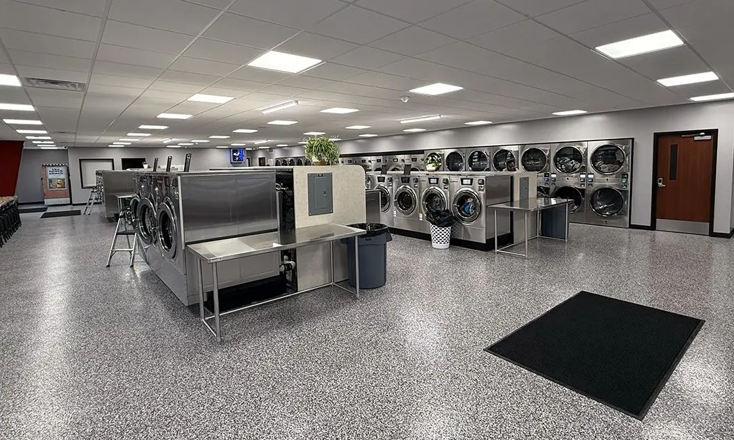 Spacious interior of Sudzy’s Laundromat in Galesburg showing washers, dryers, and folding area