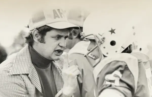 David “D-Dub” Whiteman on the sideline holding a football helmet while coaching at Abingdon High School