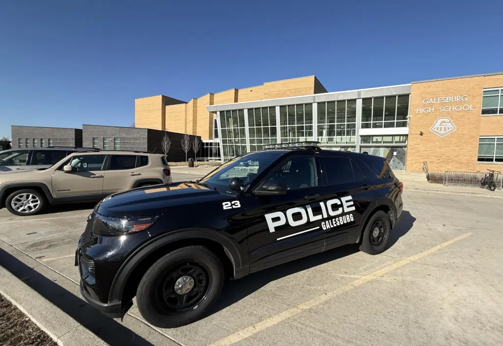 Galesburg Police vehicle parked in front of Galesburg High School entrance during precautionary increased presence