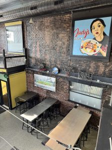 Interior view of Judy's Kitchen in downtown Galesburg, highlighting the seating area beneath the mural that will be converted into a new open kitchen for breakfast production.