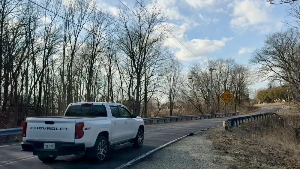 White Chevrolet truck driving on a curved section of South Lake Storey Road in Galesburg, Illinois, on February 13, 2026, highlighting safety concerns addressed in the February 2026 Traffic Advisory Committee report recommending 25 mph advisory speed limits.