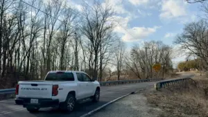 White Chevrolet truck driving on a curved section of South Lake Storey Road in Galesburg, Illinois, on February 13, 2026, highlighting safety concerns addressed in the February 2026 Traffic Advisory Committee report recommending 25 mph advisory speed limits.
