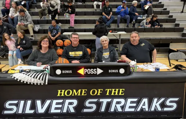Marla Clay, Brett Wolfe, Jeanine Bryant, and Jeff Lamb seated at the scorer's table at Galesburg High School's Thiel Gym