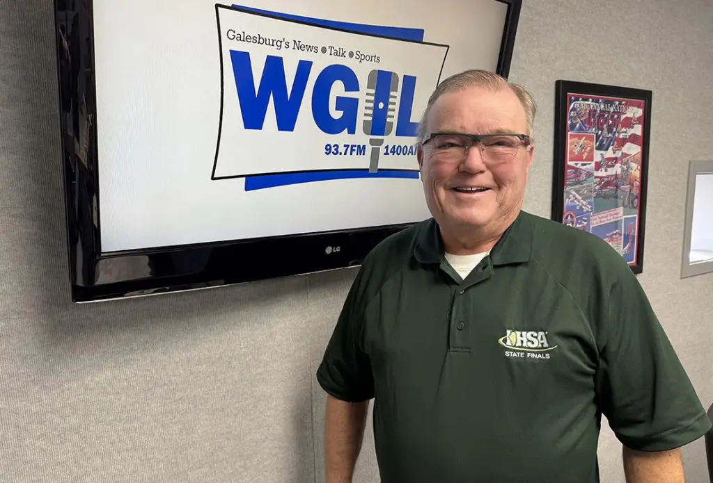 Joe Thompson standing in the WGIL studio wearing an IHSA State Finals shirt