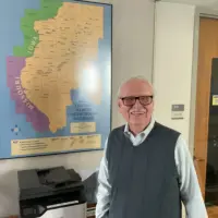 Owen Muelder standing beside the West Central Illinois Underground Railroad map at Knox College in Galesburg, Illinois